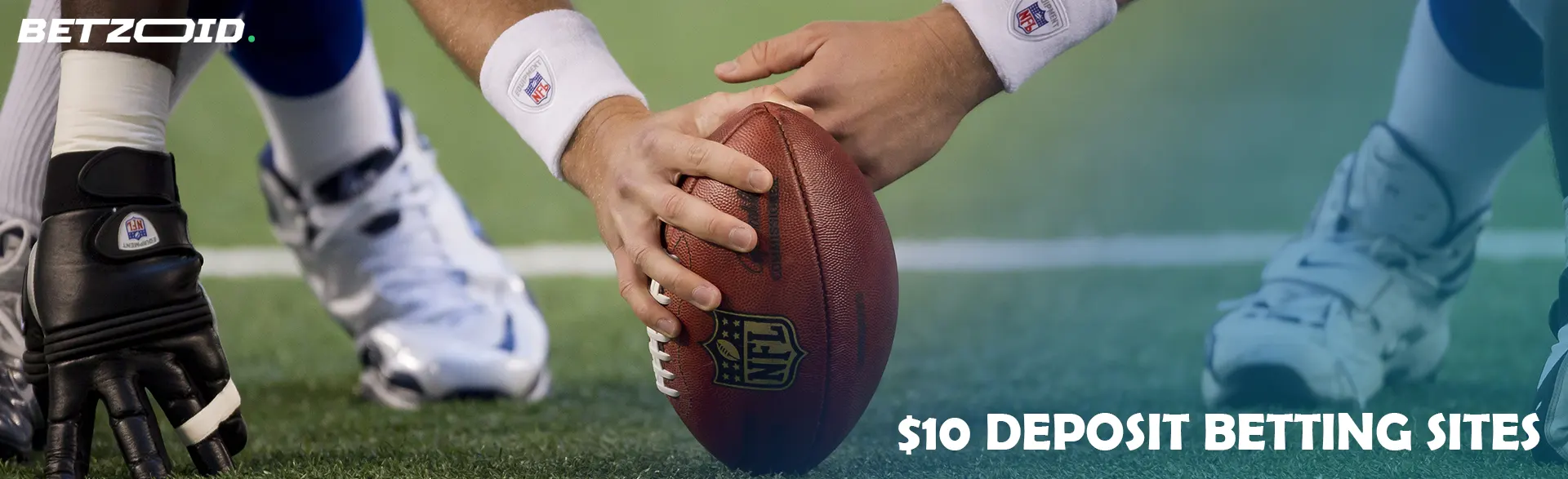 An American football player is holding the ball and preparing to kick off.