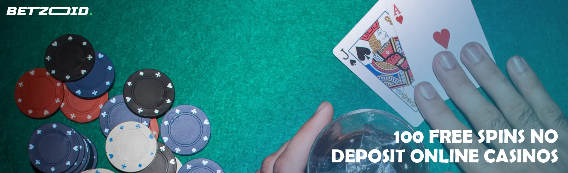 A player holds cards next to a glass of drink and casino chips.