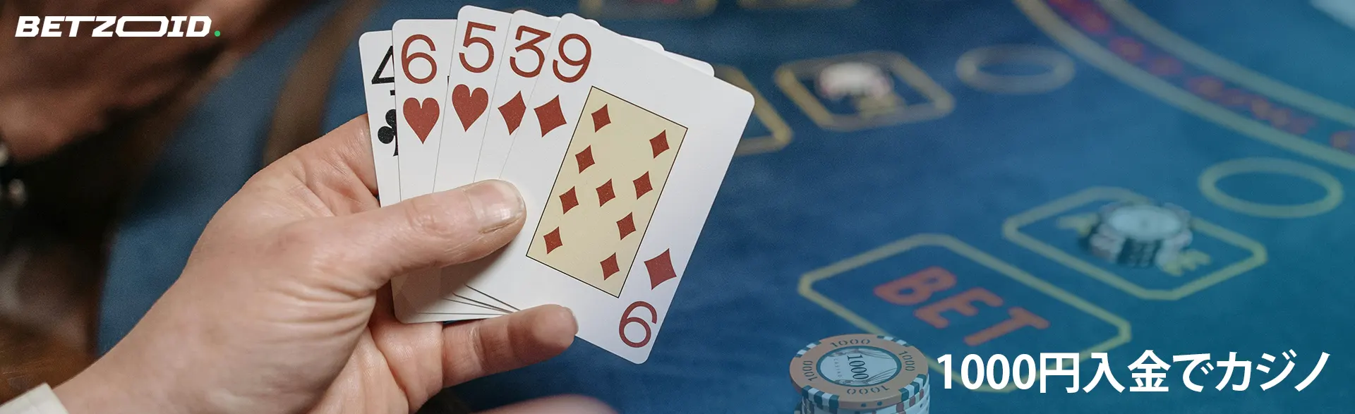 男はカジノのテーブルの背景にカードを持っています。