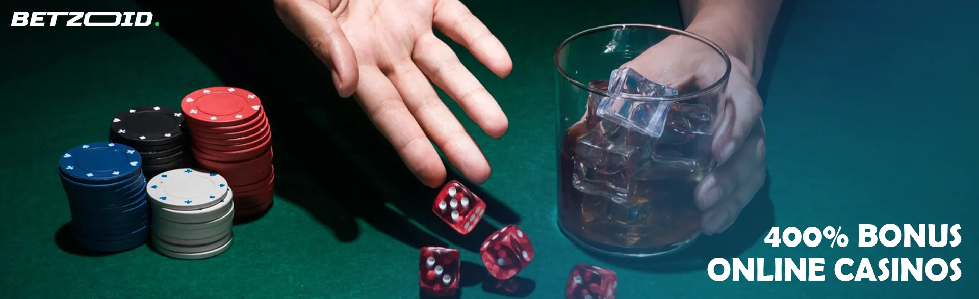 The player throws the dice on the table next to the chips and the drink in the glass.