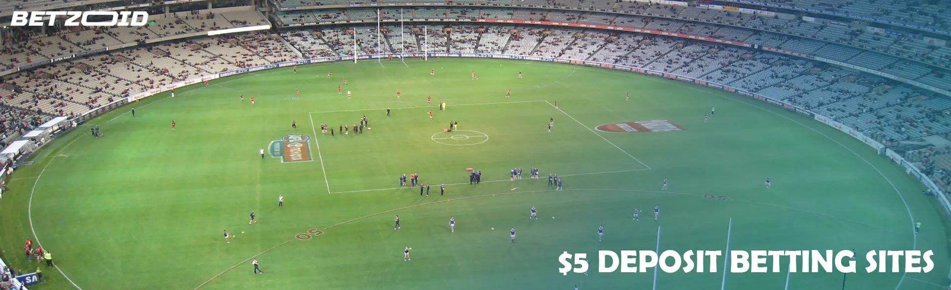 Australian football match in a large stadium with stands.