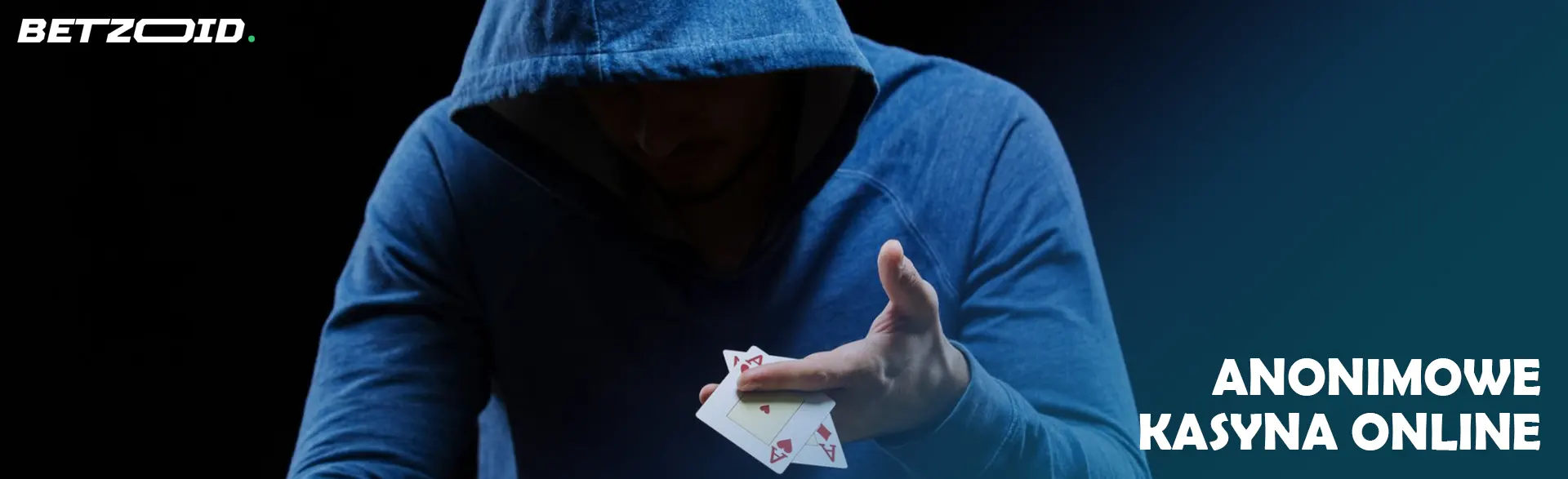 Zakapturzony gracz trzyma dwie karty do gry.