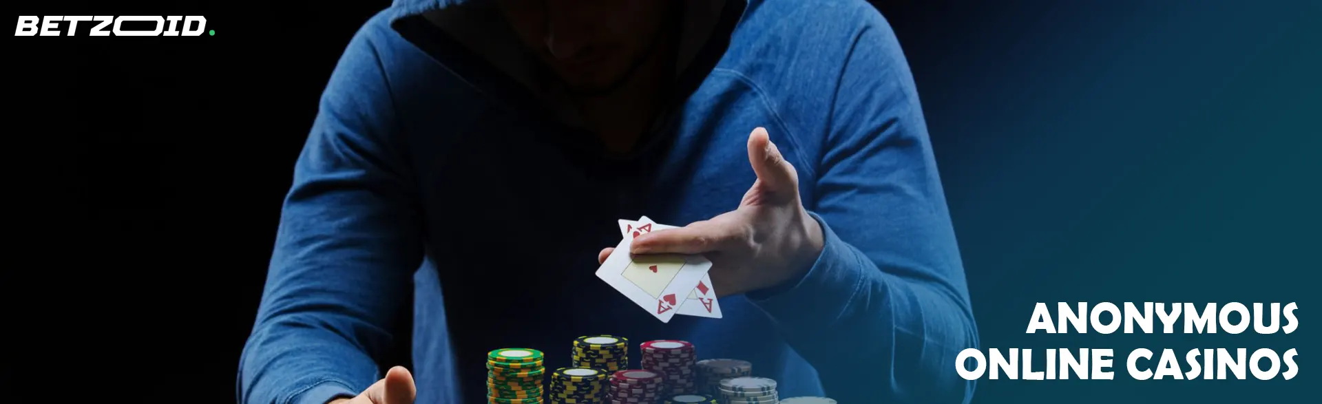 A player in a hood holds cards on a dark background.