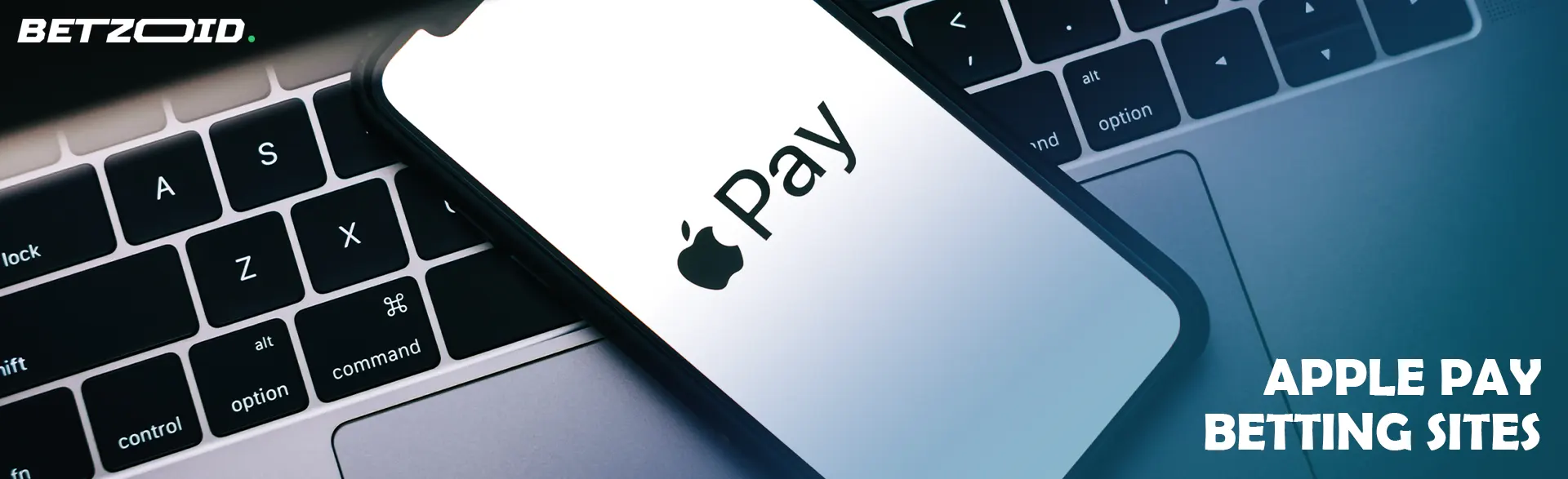 A smartphone with the Apple Pay logo lies on the keyboard.