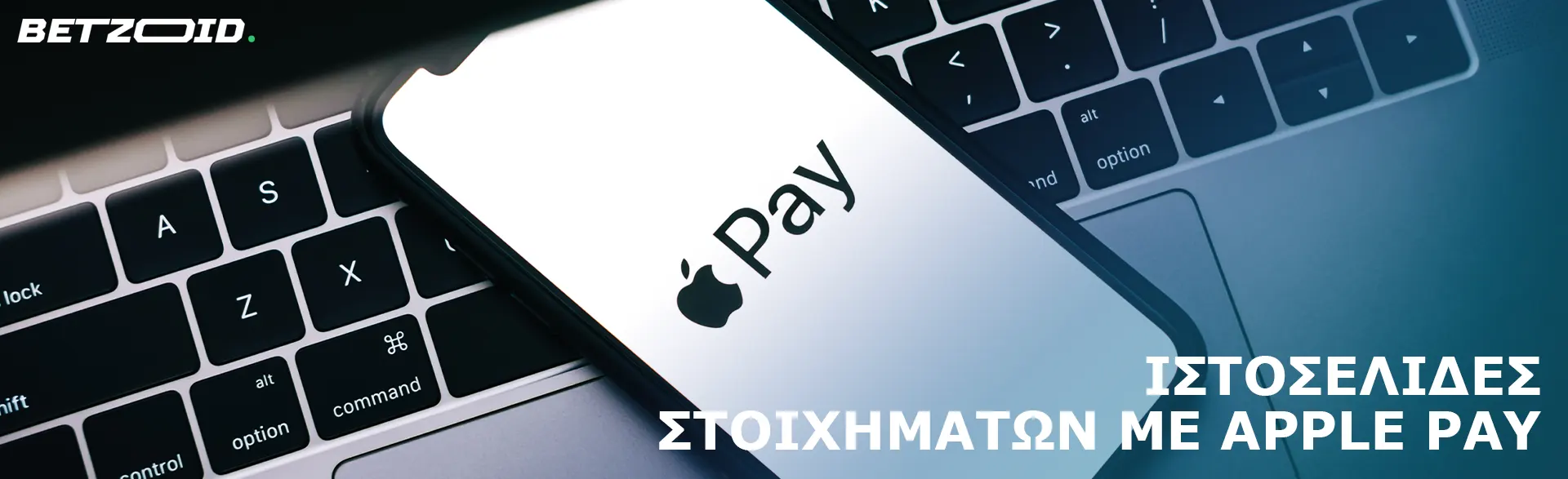 Ένα smartphone με το λογότυπο Apple Pay στηρίζεται σε ένα πληκτρολόγιο φορητού υπολογιστή.