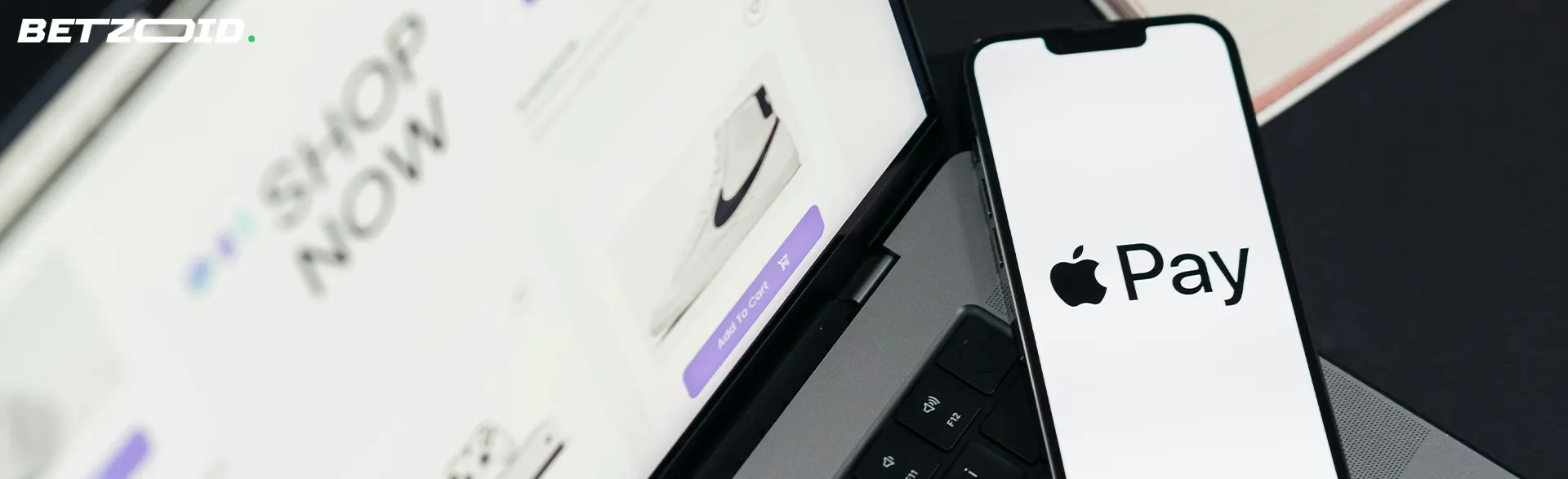 Smartphone mit Apple Pay neben Laptop.