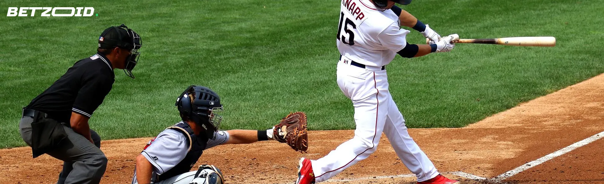 Гравець бейсболу замахується на м'яч під час гри.