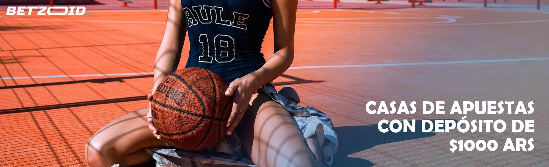 Mujer jugadora de baloncesto con una pelota en la cancha.