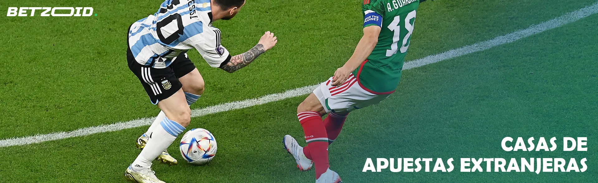 Dos futbolistas uniformados luchan por el balón en el campo.