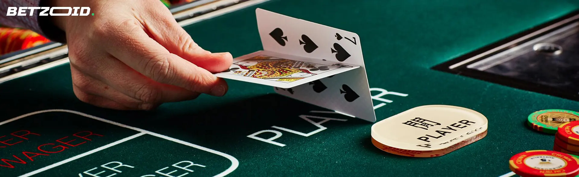 Hráč drží karty na stole kasina.