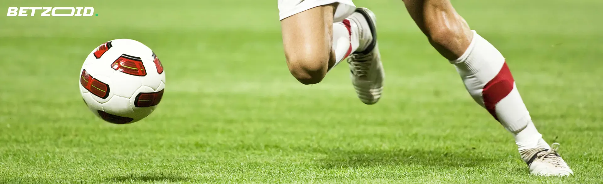 A football player runs after the ball on the field.