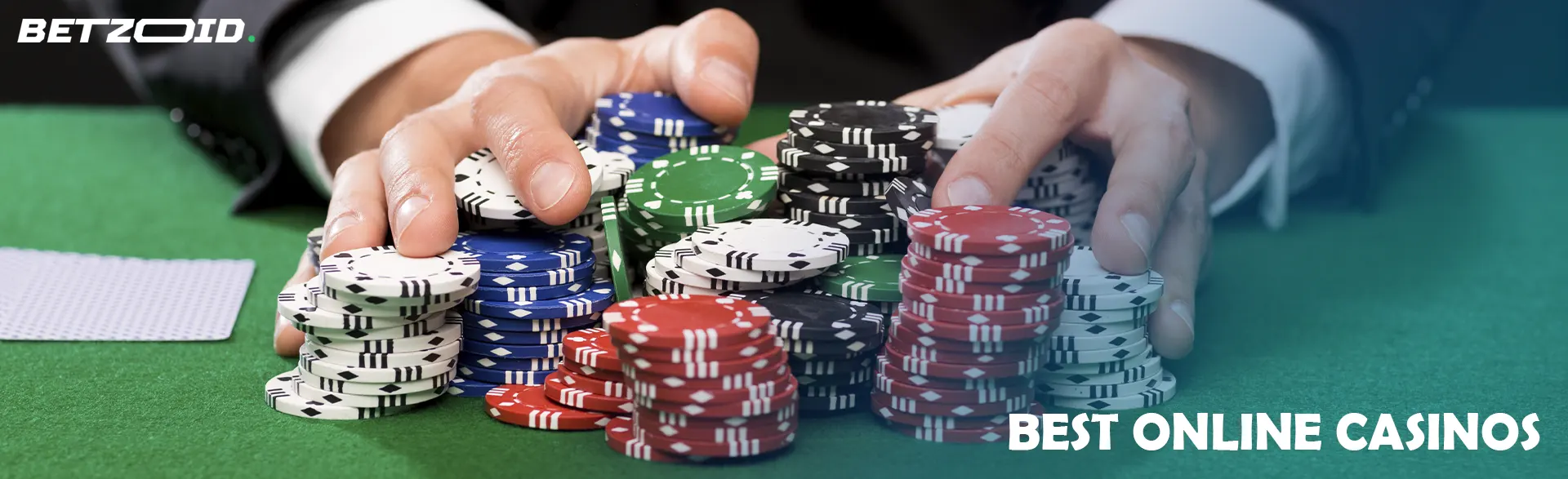 A player holds a pile of chips on a casino table.
