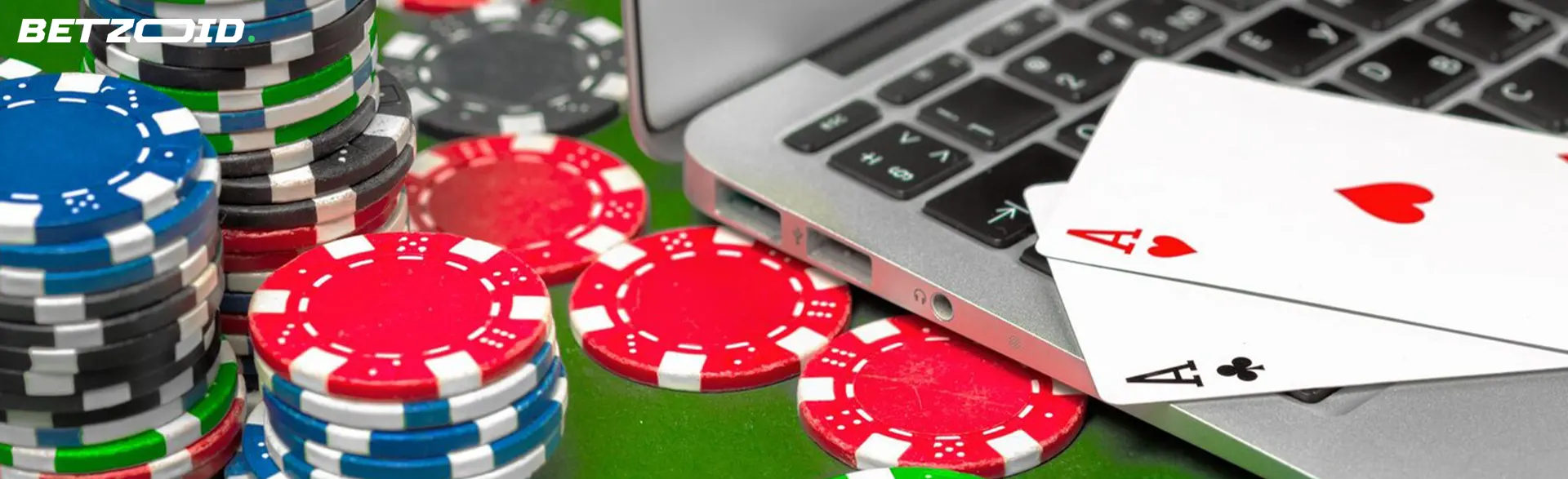 Fiches e carte da poker accanto al computer con il gioco del casinò online esteri.