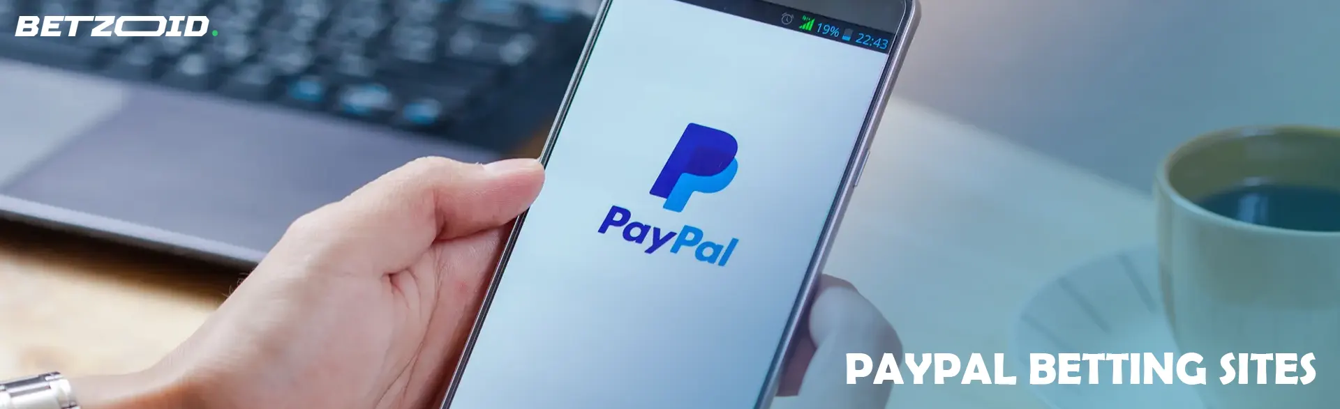Smartphone with PayPal logo in hand.