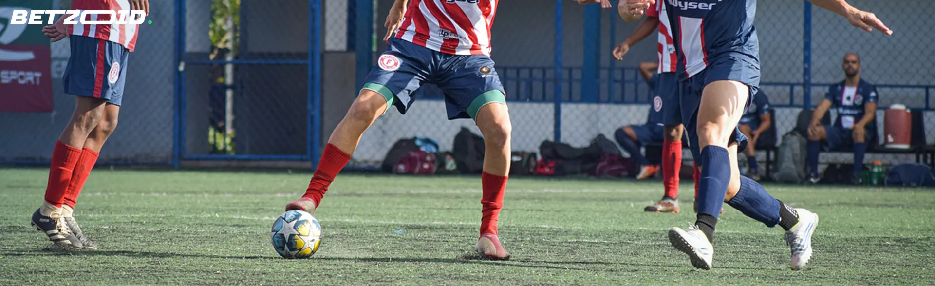 Footballers pass the ball around the field during a game.