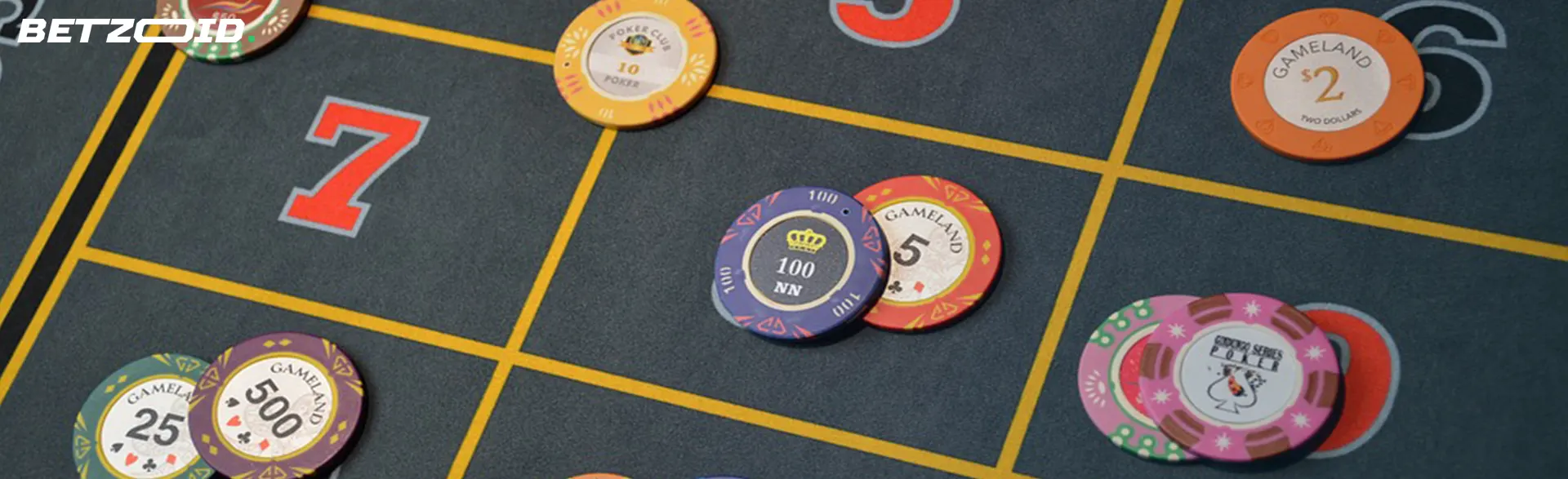 Colorful gambling chips placed on different betting squares on a roulette table.