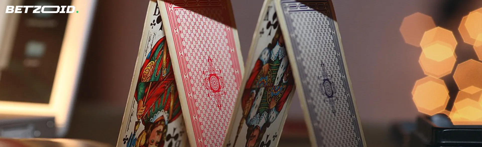 A close-up of playing cards fanned out on a table with soft lighting in the background.
