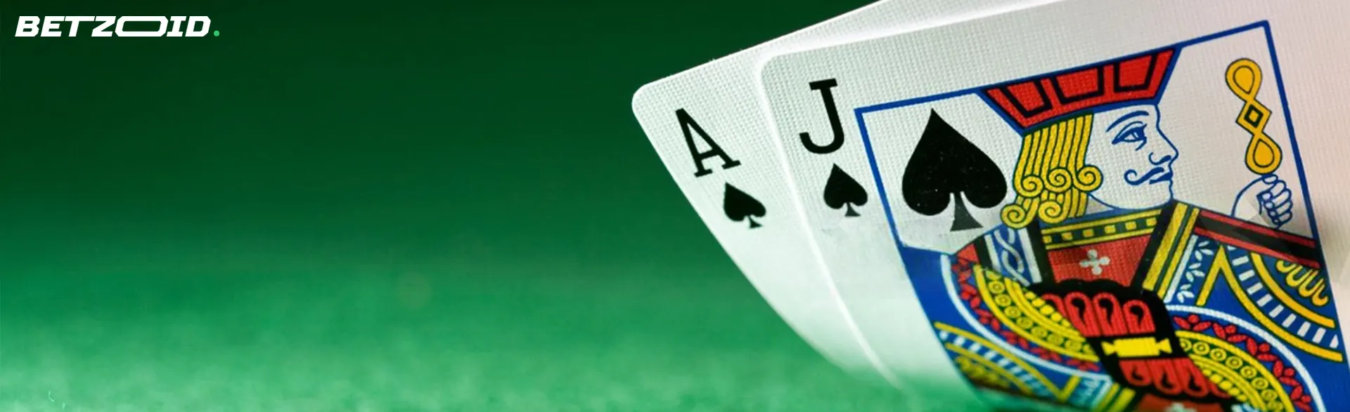A close-up of blackjack cards showing an ace and a Jack of spades on a green table.
