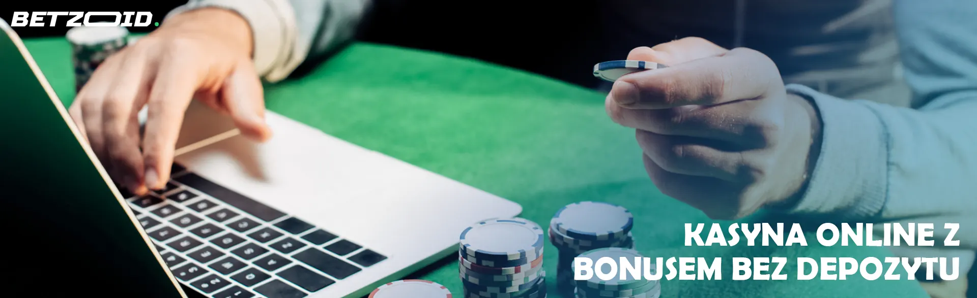 Gracz trzyma żeton kasyna w pobliżu laptopa.