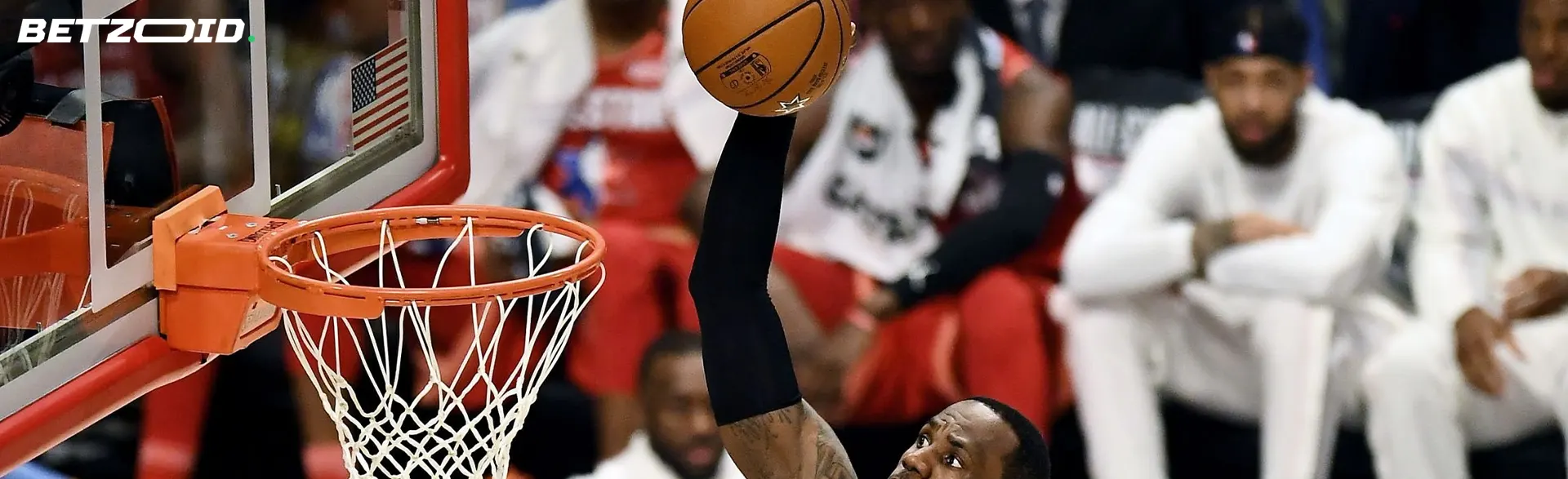 バスケットボール選手がボールをバスケットに投げ入れようとします。