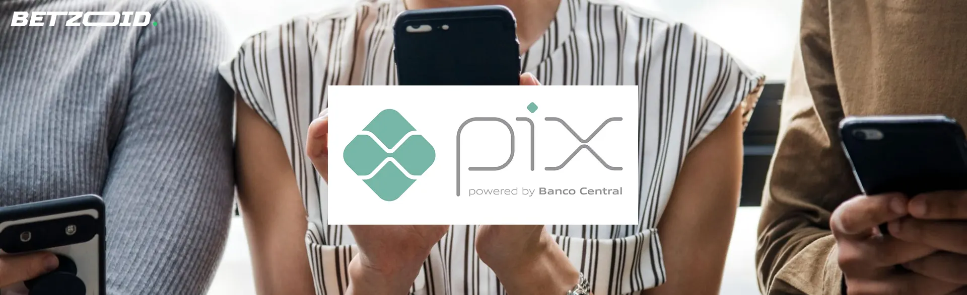 As pessoas seguram smartphones em primeiro plano do logotipo do Pix.