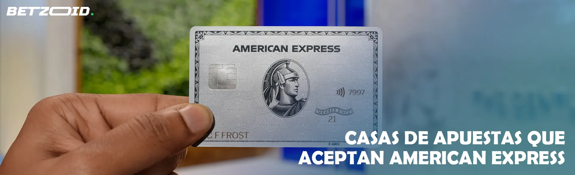 Un hombre sostiene una tarjeta American Express en su mano.