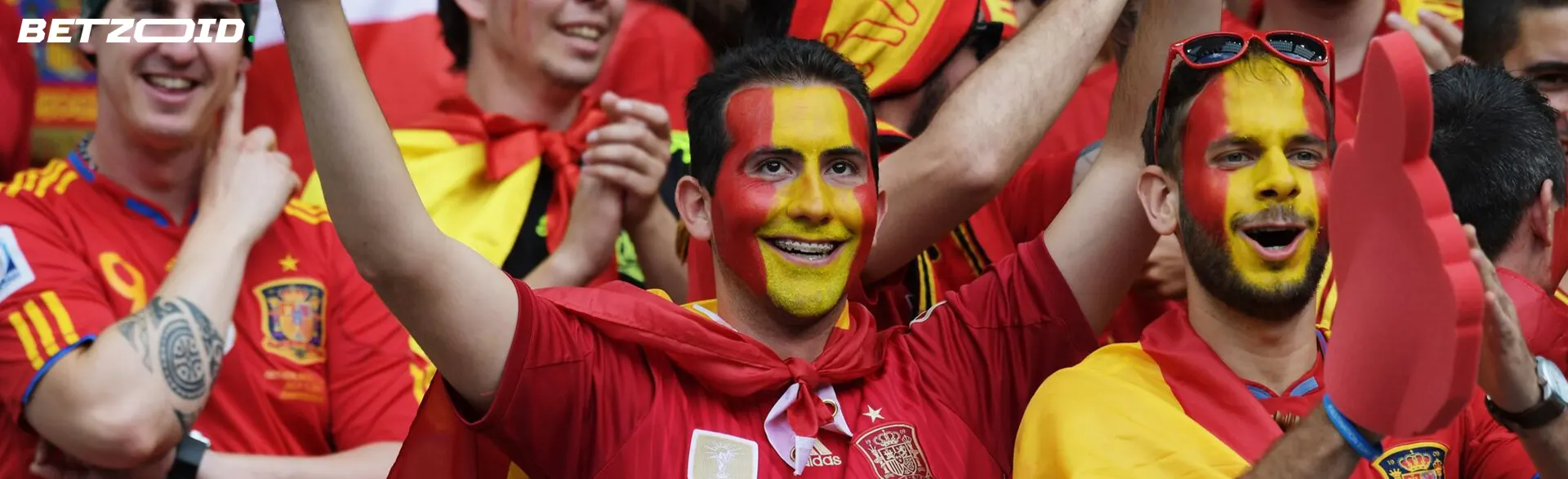 Aficionados al fútbol con caras pintadas celebrando con entusiasmo en mejores casas de apuestas futbol.