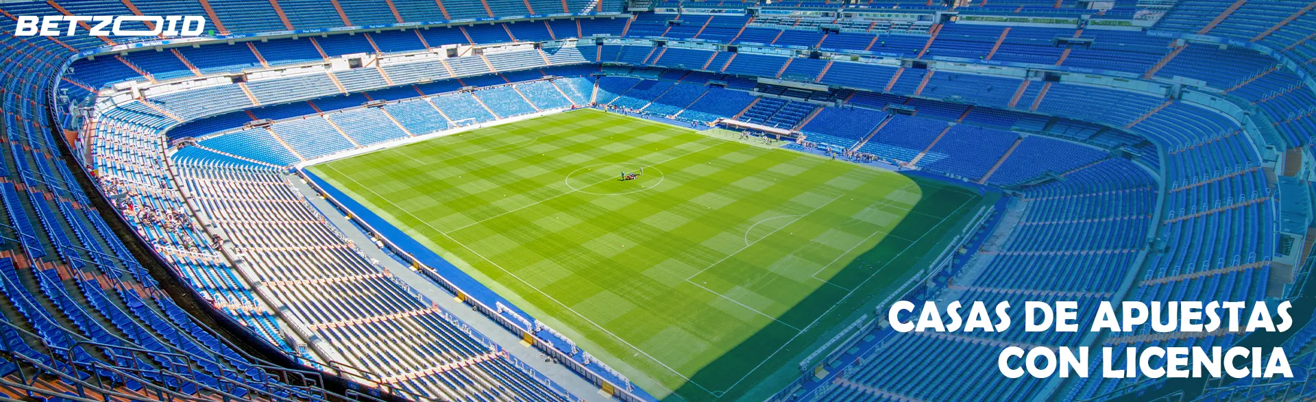 Estadio de fútbol vacío con campo verde.
