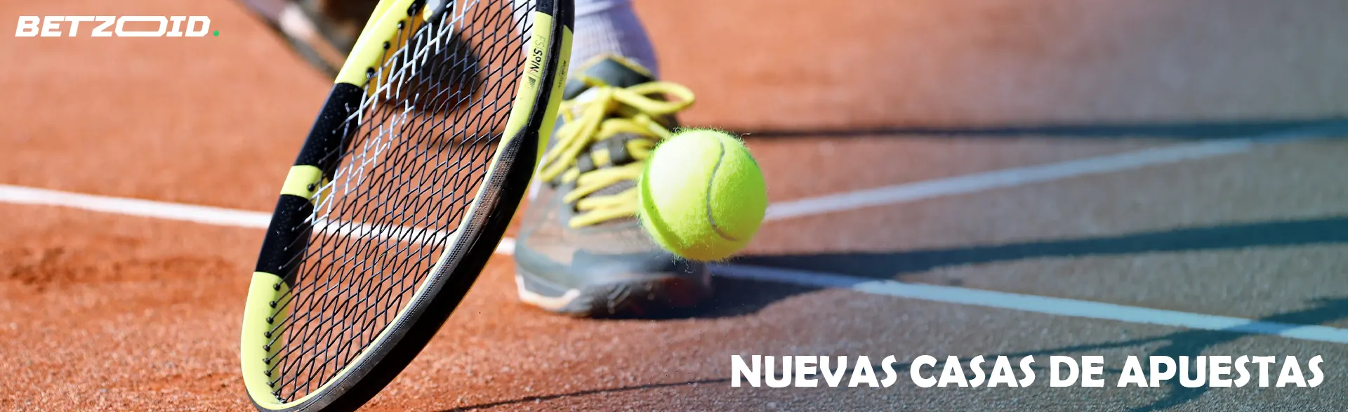 Un jugador de tenis intenta golpear la pelota con una raqueta.