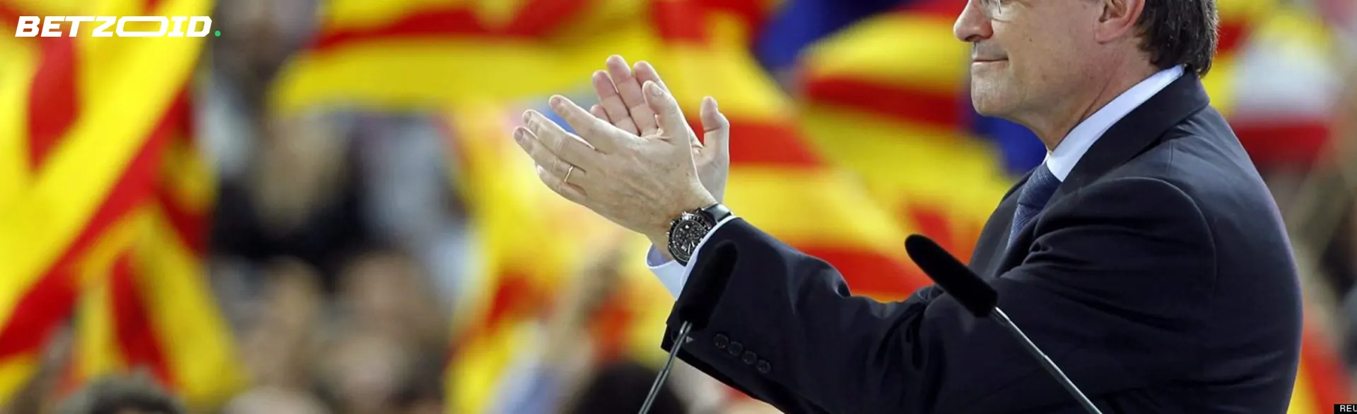 Político español aplaudiendo frente a la bandera nacional para mejores sitios para hacer apuestas políticas.