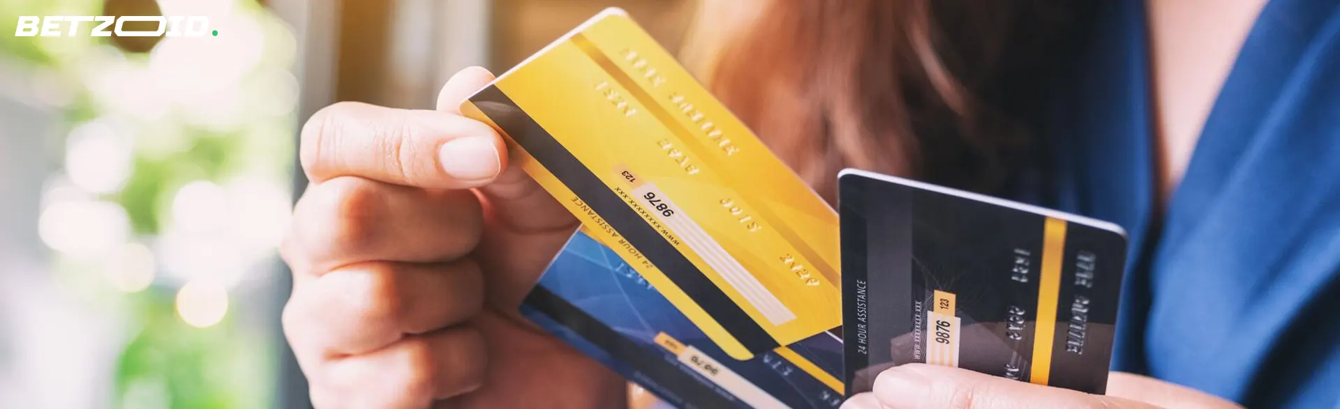 Un bărbat ține în mână carduri bancare.