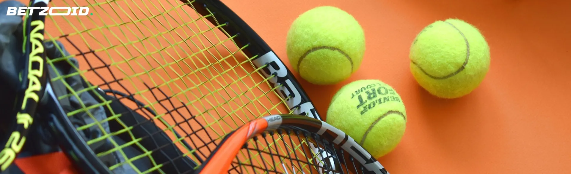 Tennis rackets next to tennis balls.