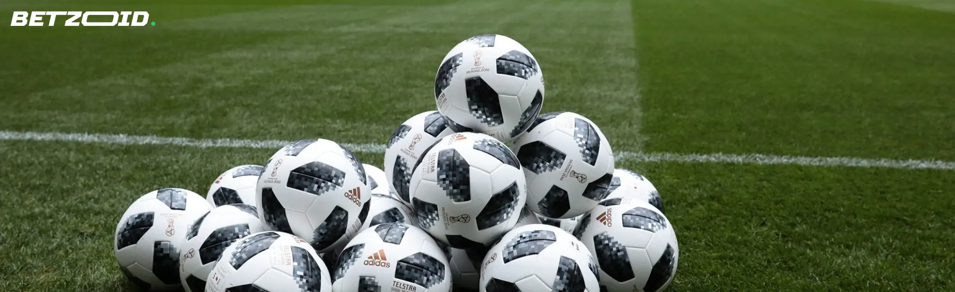 A pile of balls on a football field.