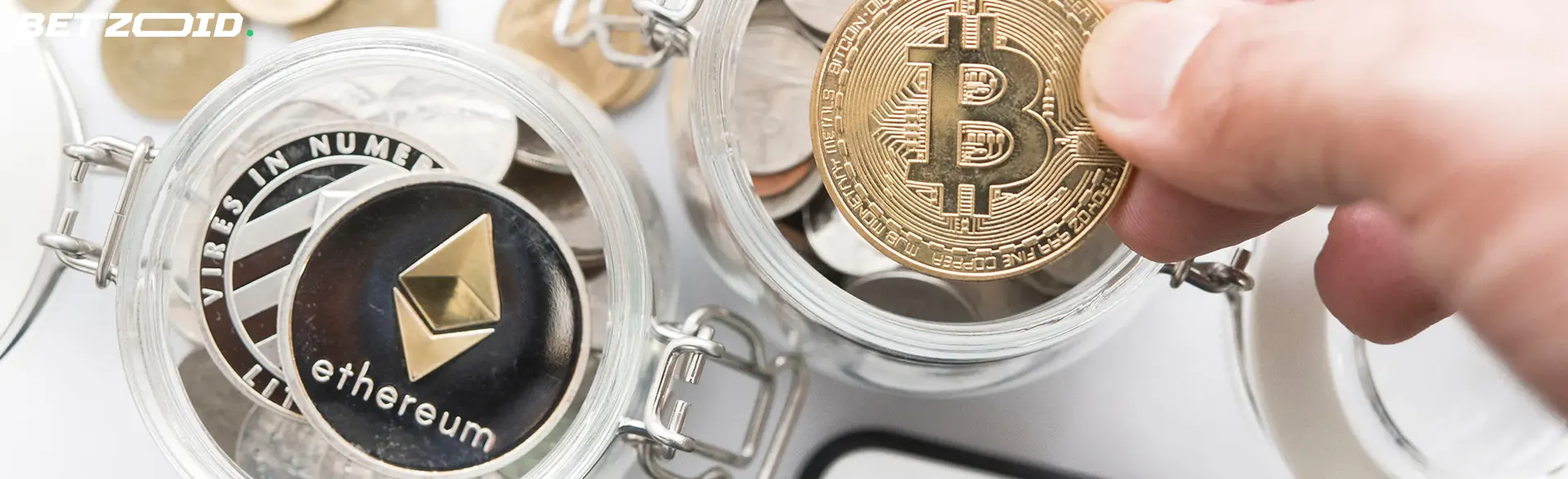 Close-up of hands holding a Bitcoin, with Ethereum and other cryptocurrencies in jars, symbolizing cryptocurrency sports betting in Canada.