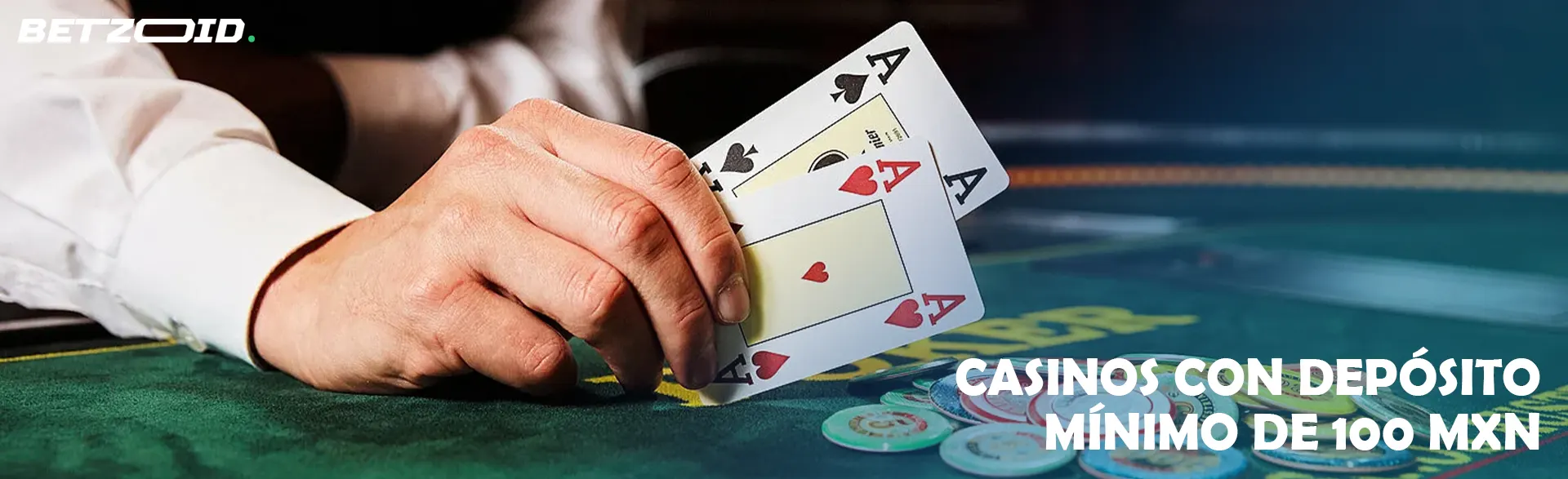 Una mano que sostiene dos cartas de ases en una mesa de póquer.