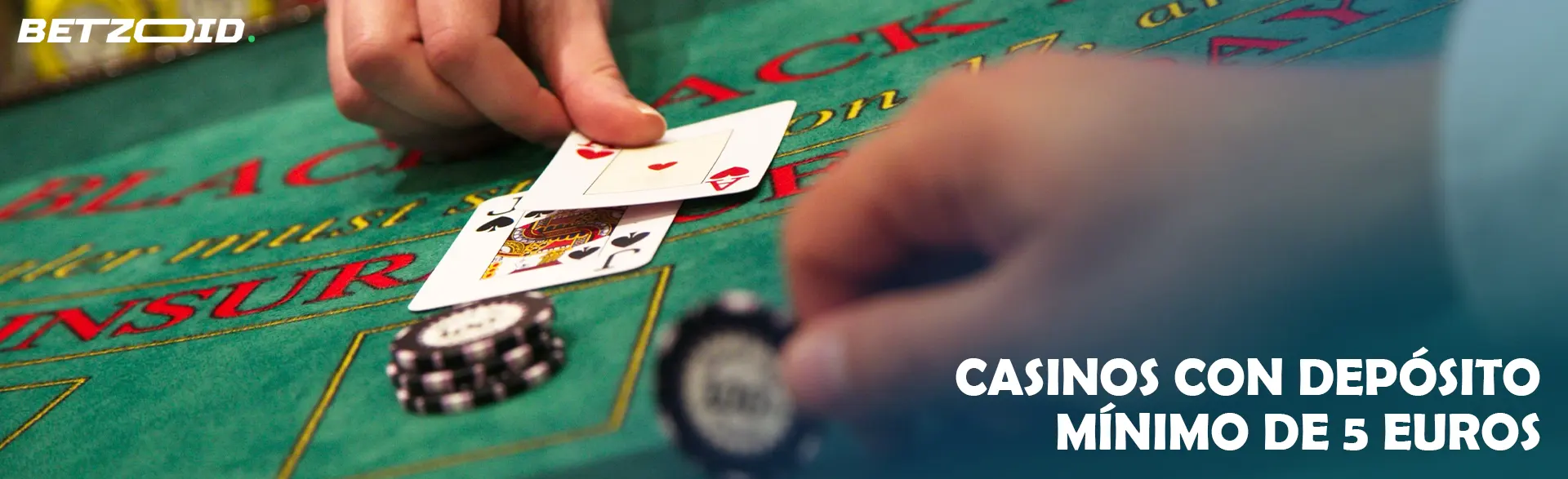 Una mano sostiene una carta en una mesa de blackjack con fichas de apuestas cerca.