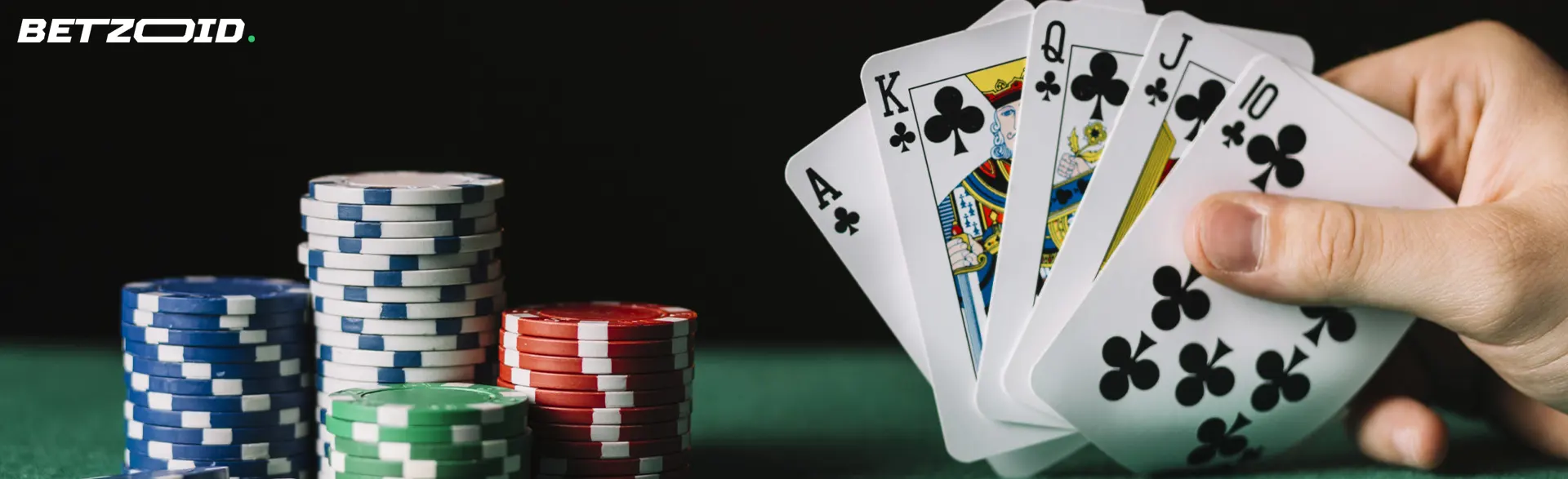 El jugador sostiene cartas junto a las fichas del casino.