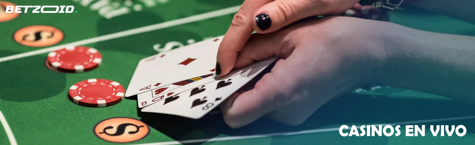 El jugador sostiene las cartas sobre la mesa del casino.