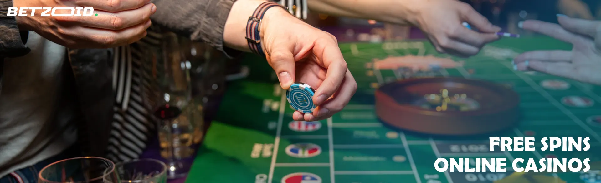 A player holds chips above a roulette table.