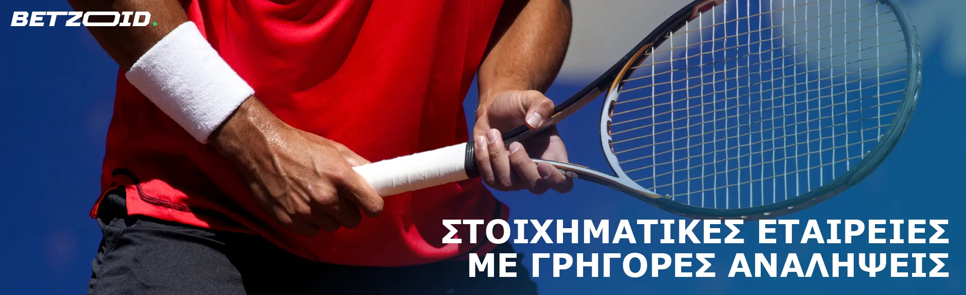 Ένας τενίστας κρατά μια ρακέτα στα χέρια του.