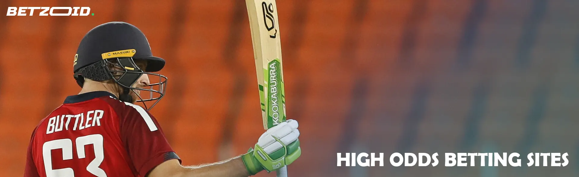 A cricketer is holding a bat.