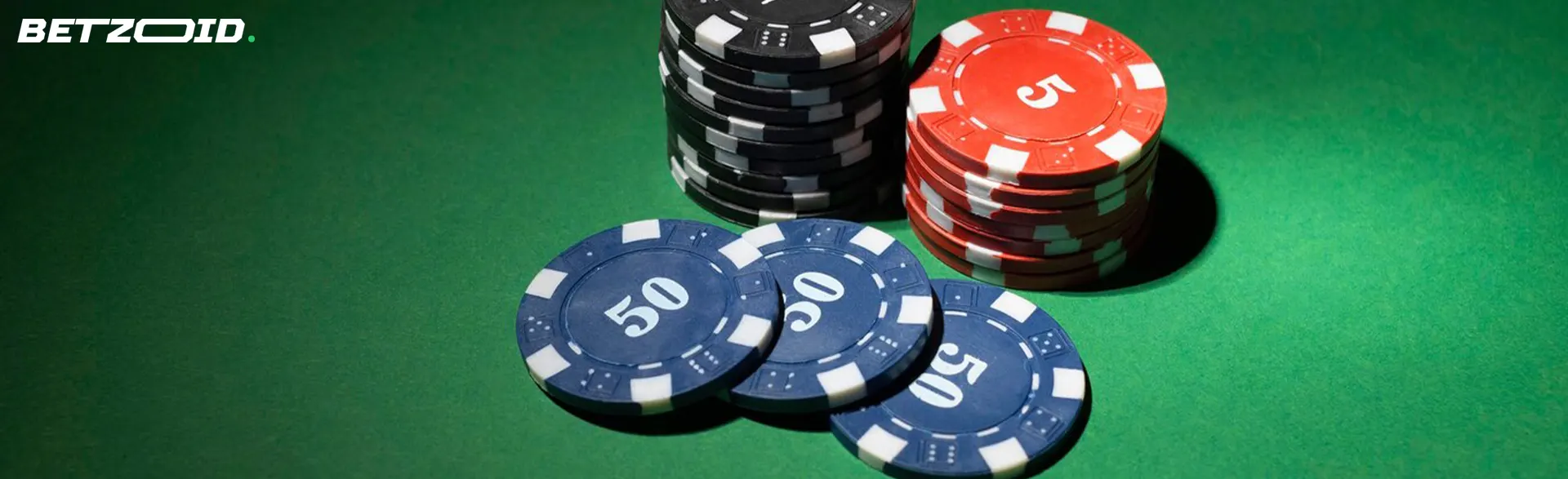 Chips of different denominations on a green table.