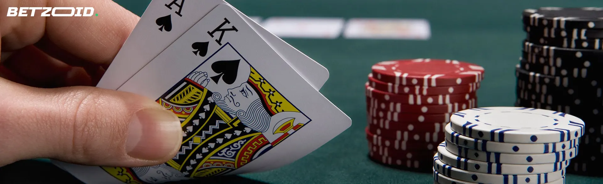 Der Spieler hält Karten neben den Casino-Chips.