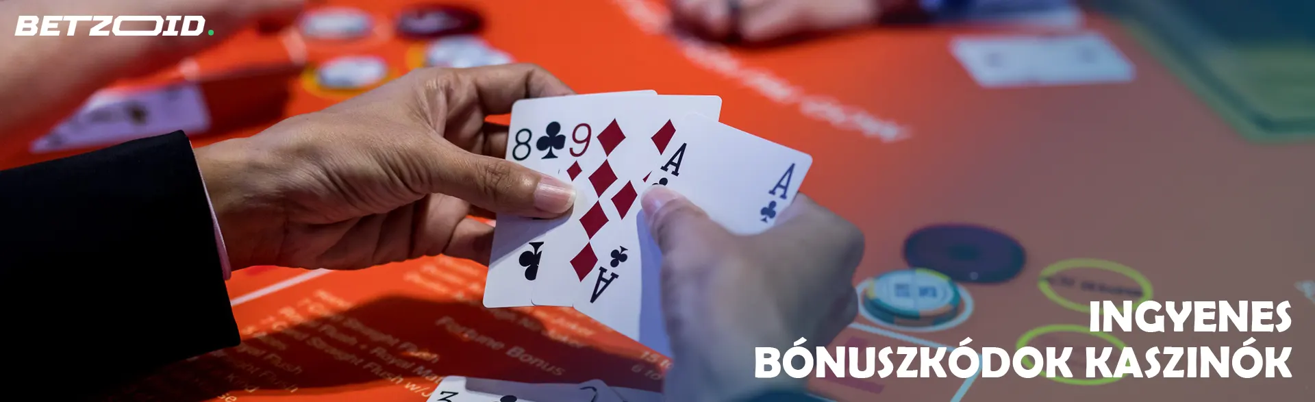 Játékos tartja a kártyákat a kaszinóasztal hátterén.