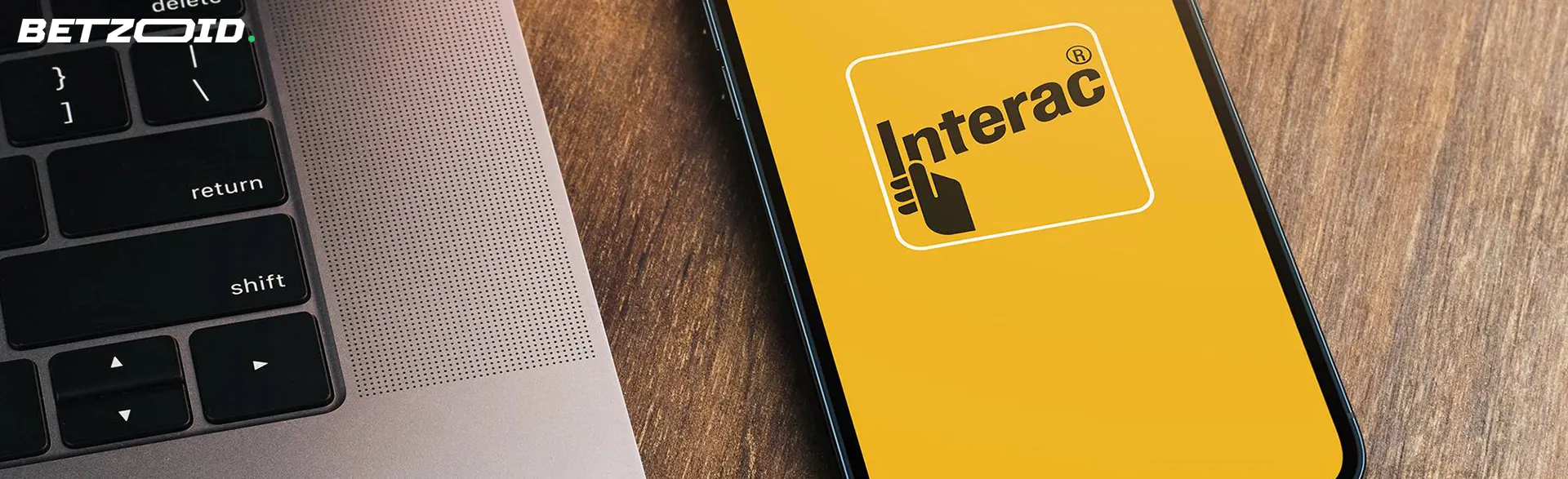 The logo Interac on the smartphone screen near the keyboard.