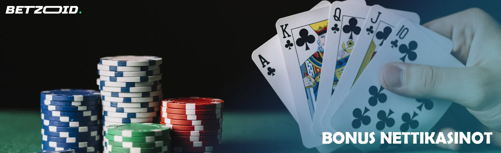 Pelaaja pitää kortteja kädessään kasinon pelimerkkien vieressä.