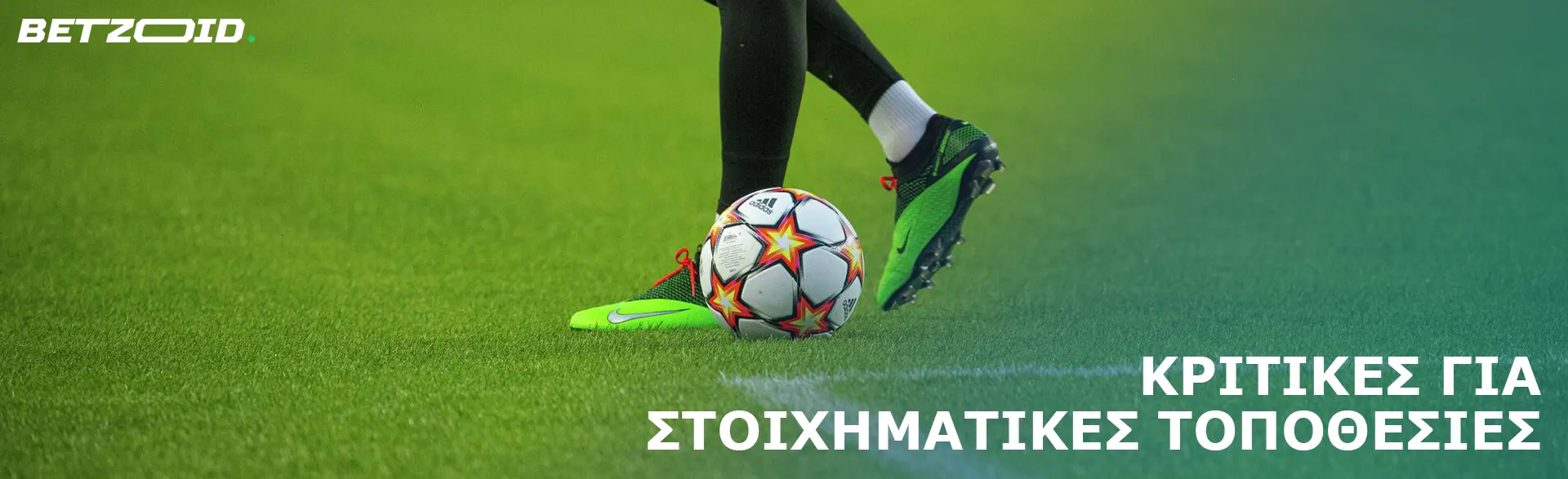 Τα πόδια του ποδοσφαιριστή δίπλα στην μπάλα στο γρασίδι.