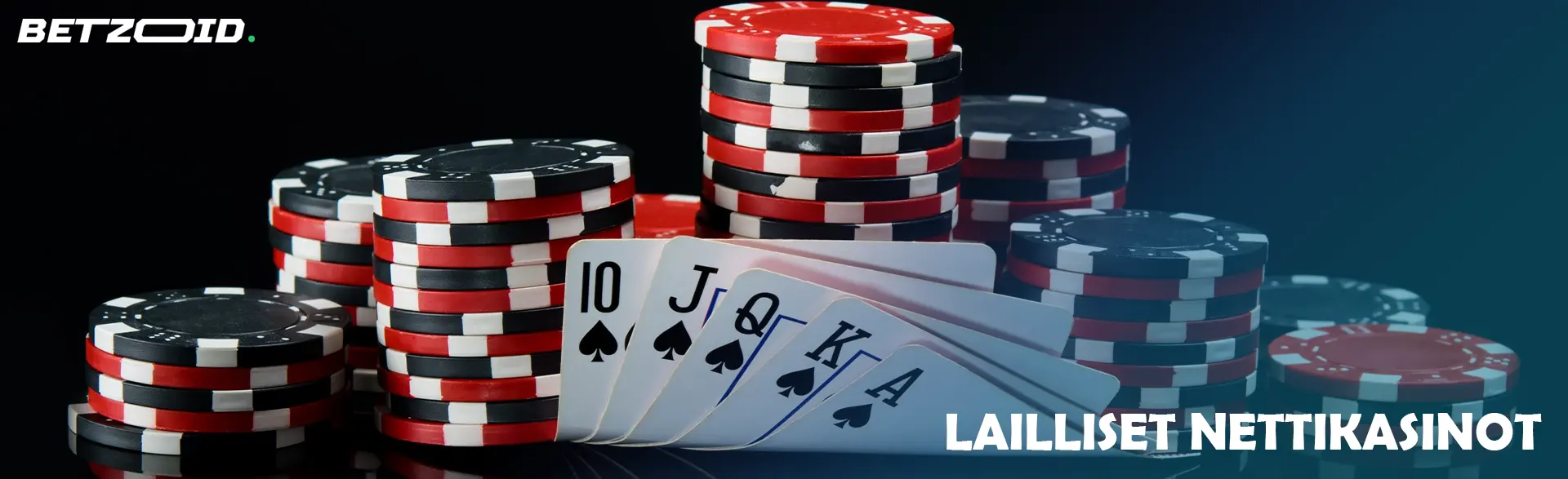 Kasino pelimerkkejä ja kortteja tummalla taustalla.