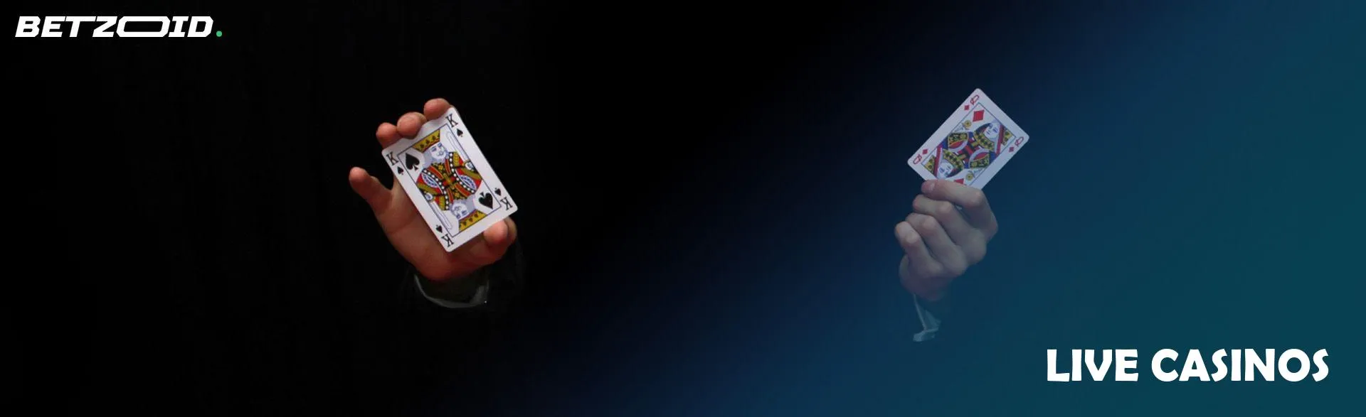 A man holds two cards on a dark background.