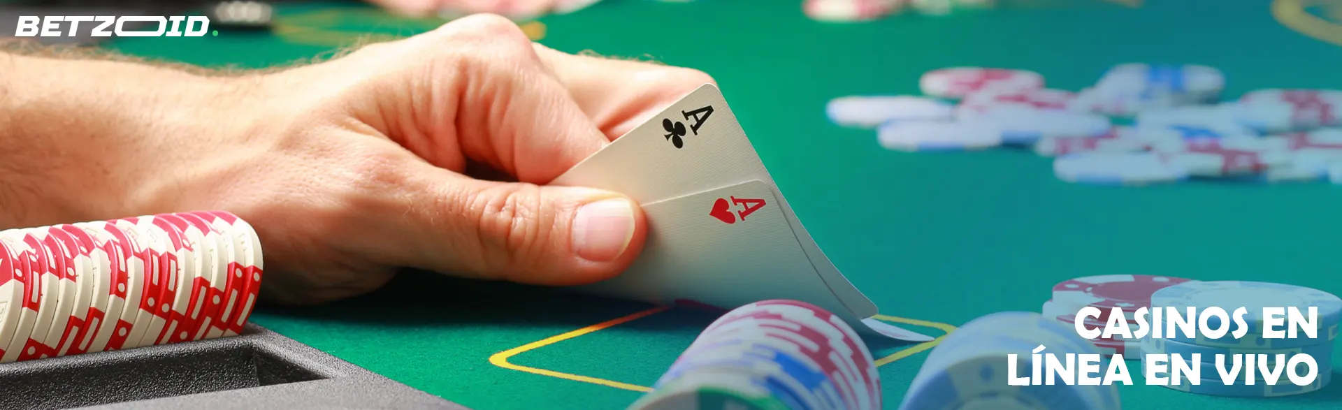 Una mano sostiene dos ases, en una mesa de casino con fichas.